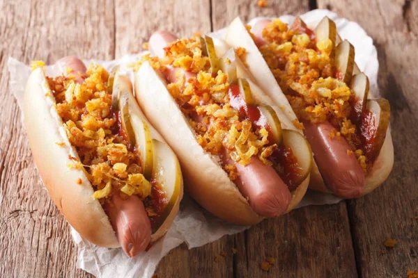 Hot Dogs Topped with Crispy Fried Onions and Gherkins