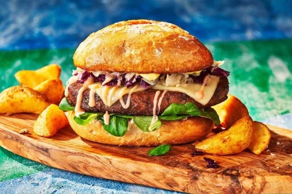 Pork Shoulder Steak in a burger bun with cheese, salad and sauces