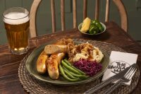 Bratwurst with jalapeno and cheese on plate with mash and green beans