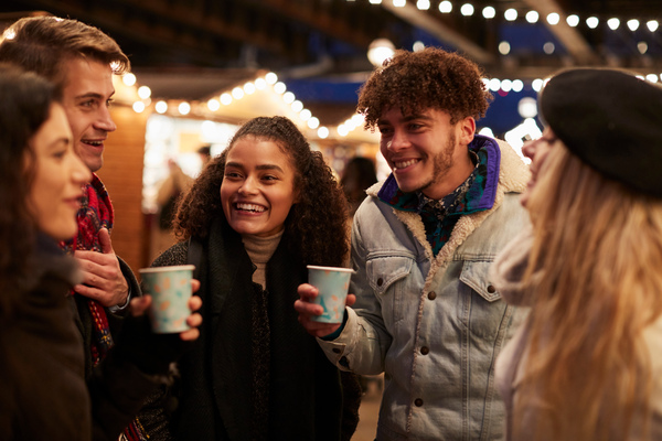 Friends enjoying hot drink xmas market